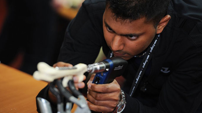 A person undertaking a demonstration of a veterinary tool, at congress.