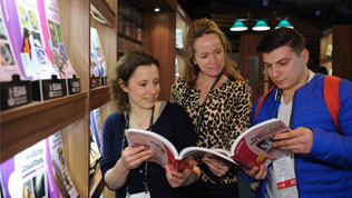 Three people browsing the BSAVA range of veterinary books available to buy