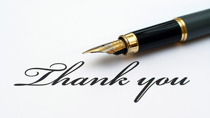 A fountain pen on top of a written note on paper, saying Thank You