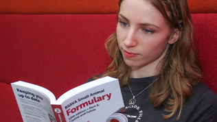 A student sat down, reading the BSAVA small animal formulary part A book